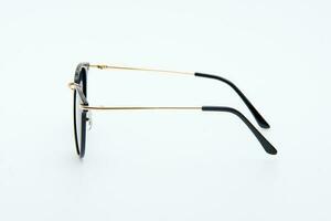 lunettes de soleil de mode montures noires et dorées sur fond blanc. photo