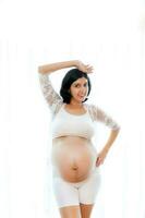 portrait de une Enceinte femme émouvant sa gros ventre proche en haut, mère, grossesse, gens et attente. femme en portant gros Enceinte estomac photo