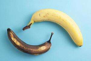 concept flatlay minimal fait de bananes mûres et pourries sur fond bleu photo