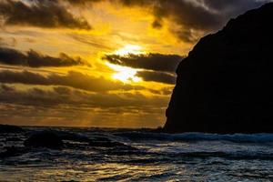 coucher de soleil et vagues se précipitant sur la plage. plage de bethels, auckland, nouvelle-zélande
