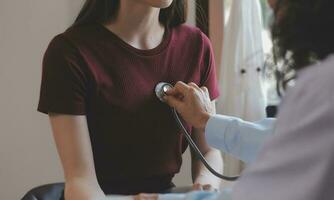 une santé visiteur avec tablette expliquant une Sénior femme Comment à prendre pilules. photo