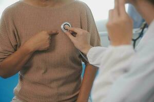 médecin utilisation stéthoscope, vérification en haut cœur battre, le déjeuner de auscultation dans médecin Bureau à hôpital. patient ouvrier a à avoir médical vérification chaque année pour sa santé ou médical vérification cardiologue photo