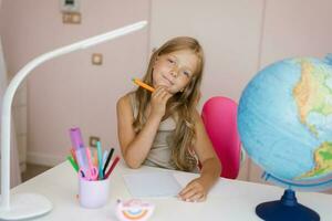 Jeune fille Faire devoirs. écolière à Accueil apprentissage photo