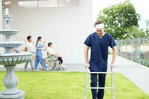 patient en utilisant mobilité marcheur dans jardin à sanatorium centre photo