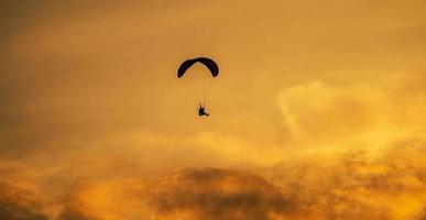 la silhouette du paramoteur au coucher du soleil photo