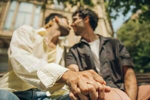 Hommes séance sur une banc dans le ville embrasser ang étreindre chaque autre photo