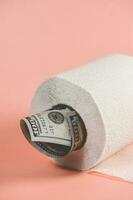 une rouleau de toilette papier avec une dollar facture collage en dehors de il photo
