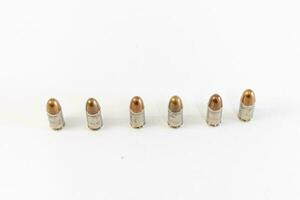 pile de d'or 9 mm pistolet balles sur une blanc Contexte photo