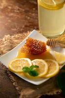 jus de citron au miel sur table en bois citrons et feuilles de sauge