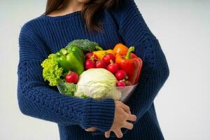 portrait d'une belle femme asiatique souriante tenant un bol plein de légumes biologiques frais isolés sur fond blanc, concept de nutrition alimentaire saine, concept de nutrition alimentaire saine, végétarien photo