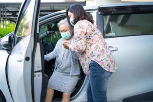 aider et soutenir les personnes âgées asiatiques ou âgées vieille dame patiente assise sur un fauteuil roulant se préparer à se rendre à sa voiture concept médical fort et sain.
