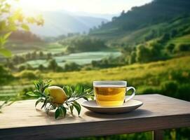 thé dans tasse sur une en bois table avec vert champ dans le Contexte photo