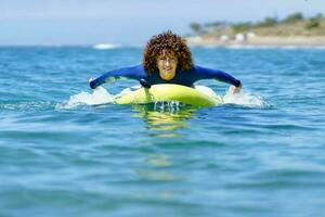 femme nager sur planche à pagaie dans mer photo