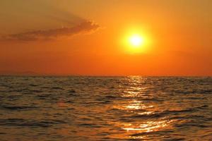 coucher de soleil orange vif sous l'océan. réflexion du soleil sur l'eau pittoresque, crépuscule jaune, paysage naturel paisible photo