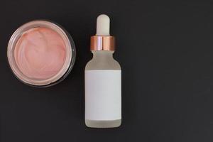 soins de la peau spa, sérum d'argile rose, soin du visage à l'huile sur fond noir photo