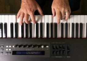 mains masculines pratiquant sur le clavier de piano électronique. photo