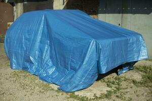 voiture est couvert avec store. bleu store sur auto. protégé Véhicules. photo