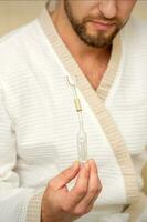 Jeune caucasien homme recevoir nasale inhalation maholda avec essentiel pétrole dans le nez à une hôpital. photo