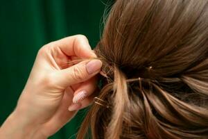 coiffeur fait du coiffures pour une Jeune femme dans beauté salon proche en haut. photo