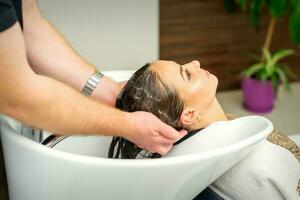 magnifique caucasien femme la lessive cheveux dans une beauté salon. photo