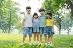 groupe de mignonne asiatique des gamins ayant amusement dans le parc photo