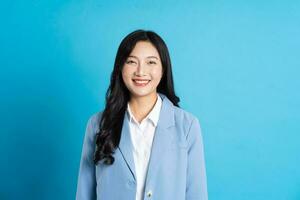 portrait de asiatique affaires femme posant sur bleu Contexte photo
