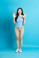 plein corps image de magnifique asiatique fille posant sur bleu Contexte photo