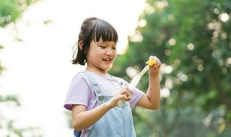 portrait de asiatique fille en jouant soufflant bulles photo