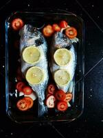 une plat de mer basse avec Cerise tomates cuit dans le four, dans une délicieux italien cuisine de Ligurie photo