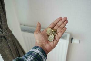 pièces de monnaie sur main contre radiateur à enregistrer sur énergie facture photo