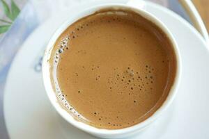 Haut vue de chaud café avec bulle sur blanc Contexte photo