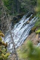 cascade fonctionnement vers le bas côté de une montagne photo