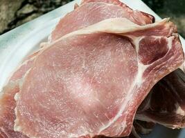 Frais portionné brut porc travers de porc steaks sur une en bois cuisine planche. pièces de porc Viande fermer photo
