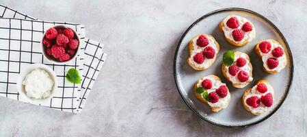 sucré bruschettas avec fromage blanc fromage et framboises sur une assiette Haut vue la toile bannière photo