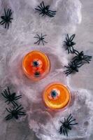 Halloween fruit du sang cocktail avec yeux et Orange dans des lunettes Haut et verticale vue photo