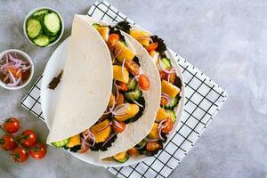 tortilla avec poulet pépites, légumes, oignons et salade sur une assiette Haut vue photo