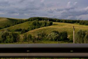 vue de le vert collines et le route clôture photo