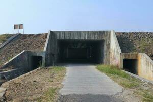 petit tunnel. Extérieur paysage de vide rue passer par une petit tunnel en dessous de le Autoroute et agricole des champs espace pour texte. photo