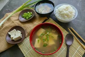 miso soupe ou Japonais miso soupe dans bol sur le tableau. Japonais cuisine dans le forme de soupe avec dashi ingrédients, Tofu, fruit de mer, légumes, et surmonté avec miso à goût photo