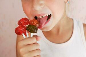 enfant mange bonbons. fille a carie sur dents. photo