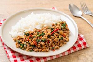 Basilic thaï sauté avec porc haché sur riz garni photo