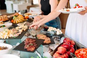 la main des gens prend de la nourriture sous forme de buffet au restaurant de l'hôtel. photo