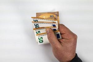 main d'homme comptant 50 billets en euros photo