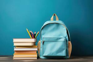 école sac et manuels dans de face de une bleu Contexte. retour à école concept photo