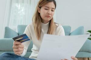 femme asiatique stressée et mal à la tête avec de grosses factures ou factures pas d'argent à payer pour les dépenses et la dette de carte de crédit. pénurie, problèmes financiers, hypothèque, prêt, faillite, faillite, pauvre, portefeuille vide photo