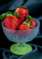 tasse de fraises mûres sur fond noir photo