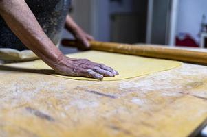 détail rouler la pâte avec un rouleau à pâtisserie photo