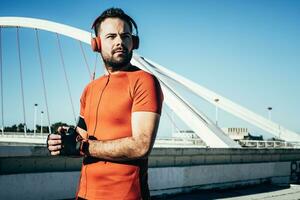 homme en jouant des sports et écoute à la musique avec écouteurs photo