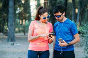 caucasien couple en train de regarder mobile application et exercice dans une parc. en bonne santé vivant concept photo