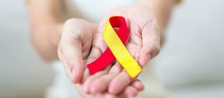 femme en portant rouge et Jaune ruban. monde hépatite journée conscience mois, 28 juillet, foie cancer, jaunisse, cirrhose, échec, agrandi, hépatique encéphalopathie et santé concept photo